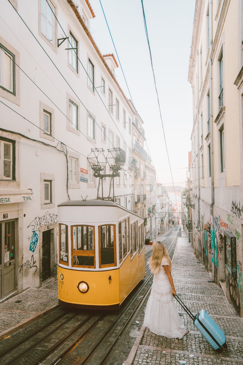 girl walks toward yellow tram in Lisbon