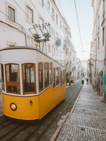 yellow tram on empty steep cobblestone street